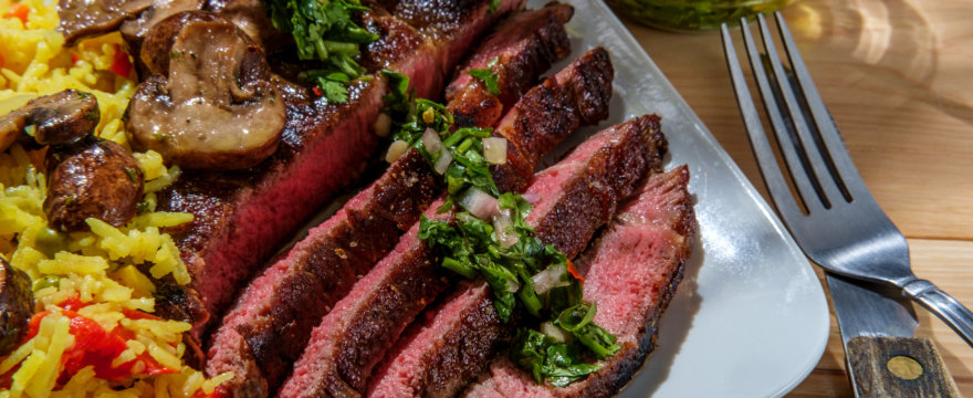 Classic Argentine steak with chimichurri sauce and yellow rice.